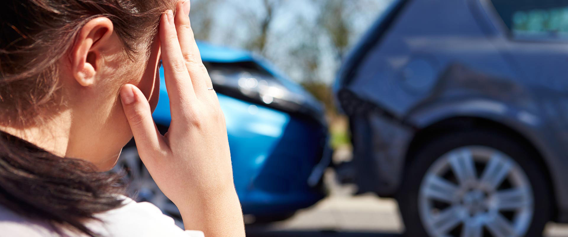 woman holding head after auto accident