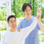 An older adult smiling during a gentle physical mobility session, demonstrating how chiropractic care for seniors supports active living in Henderson.