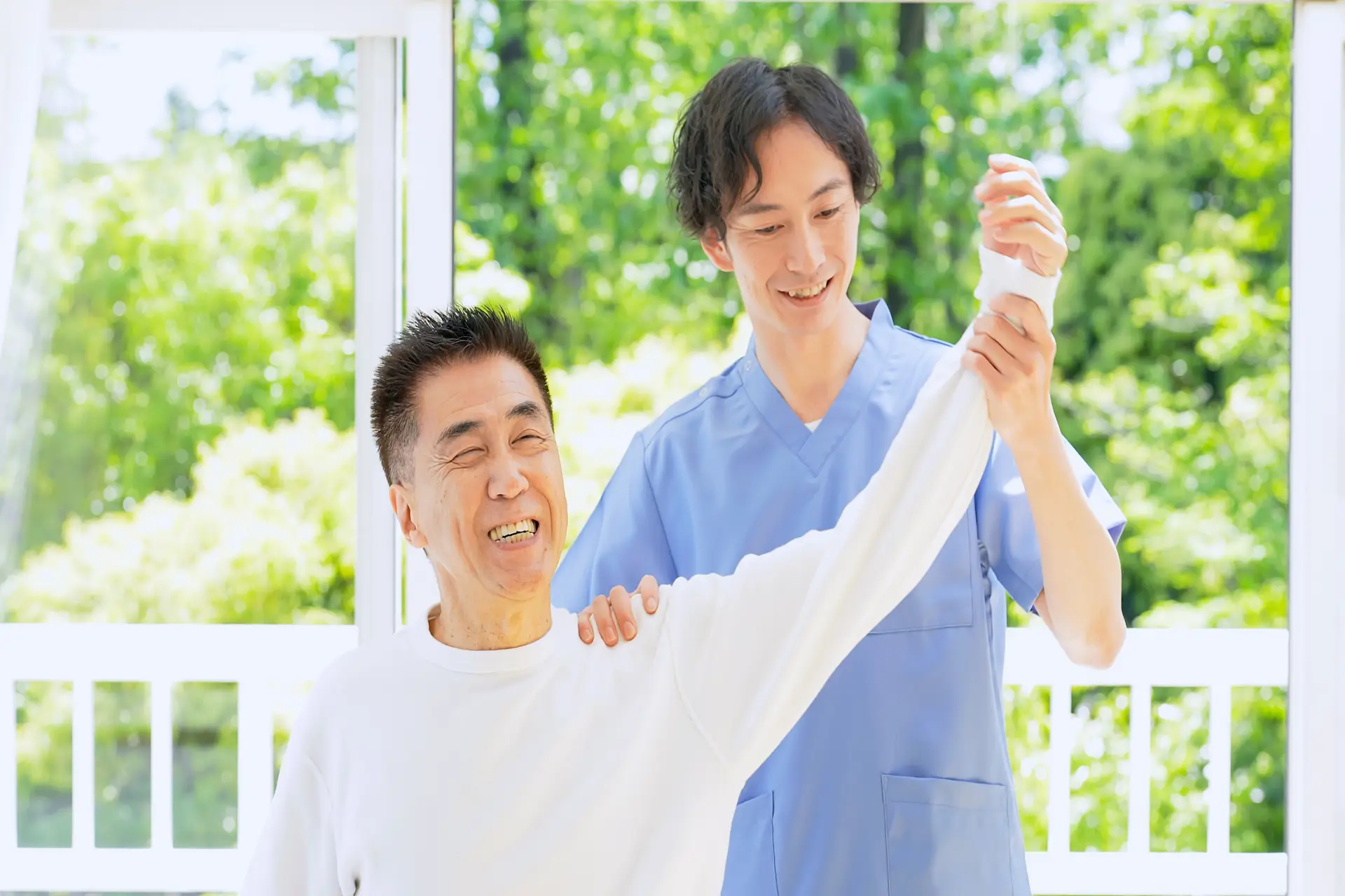 An older adult smiling during a gentle physical mobility session, demonstrating how chiropractic care for seniors supports active living in Henderson.