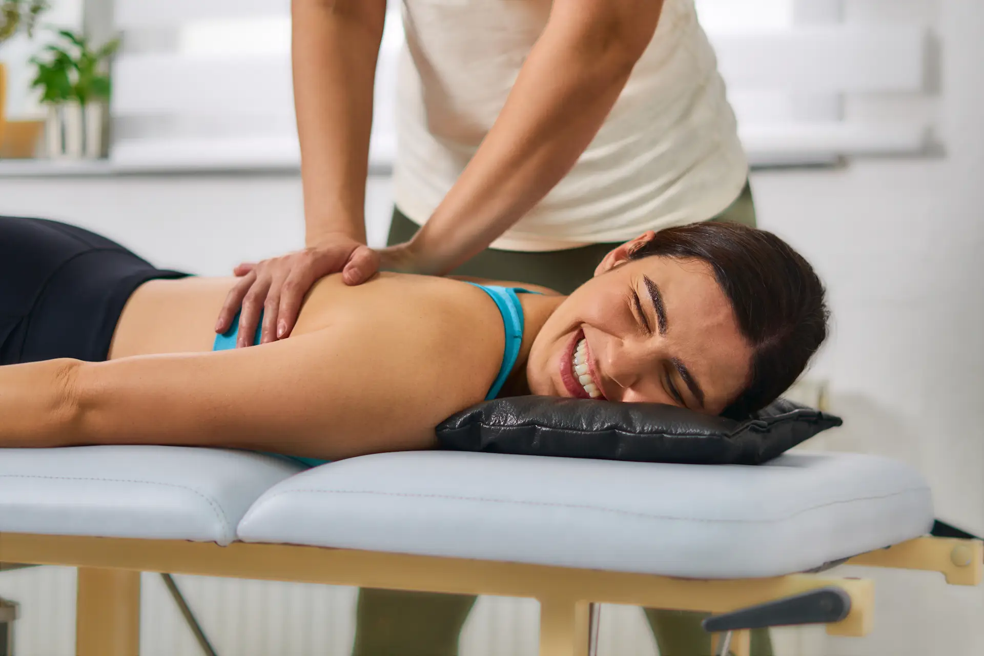 A patient smiling during a precise spinal adjustment by a Henderson chiropractor, showcasing how care relieves nerve strain to restore body energy.